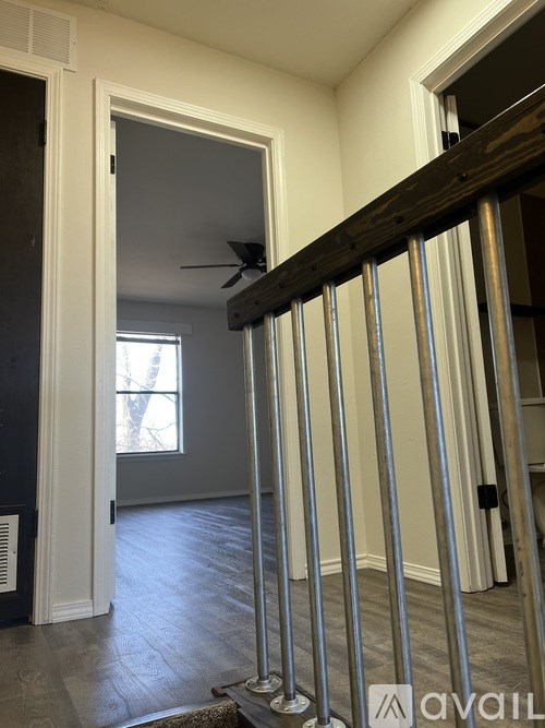 A room with a window and a fan on the ceiling.