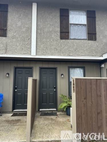 A house with a grey wall and a brown fence.
