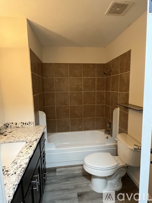 A bathroom with a white toilet, a bathtub, and a sink.