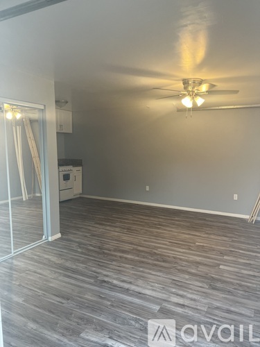 A room with a ceiling fan and wooden flooring.