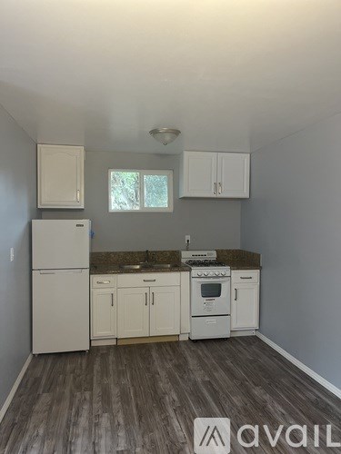 A kitchen with white appliances and cabinets.