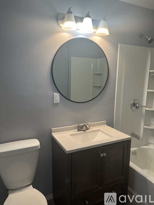 A bathroom with a white toilet, sink, and mirror.