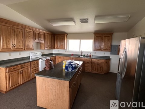 A kitchen with wooden cabinets and a black countertop.