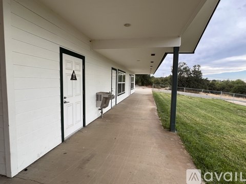 A white building with a black door and a sign that says "AVAILABLE".