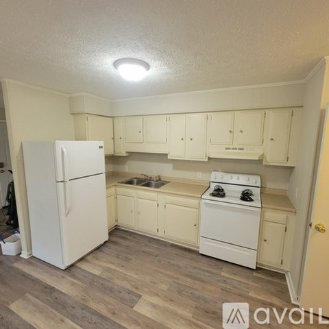 A kitchen with white appliances and cabinets.