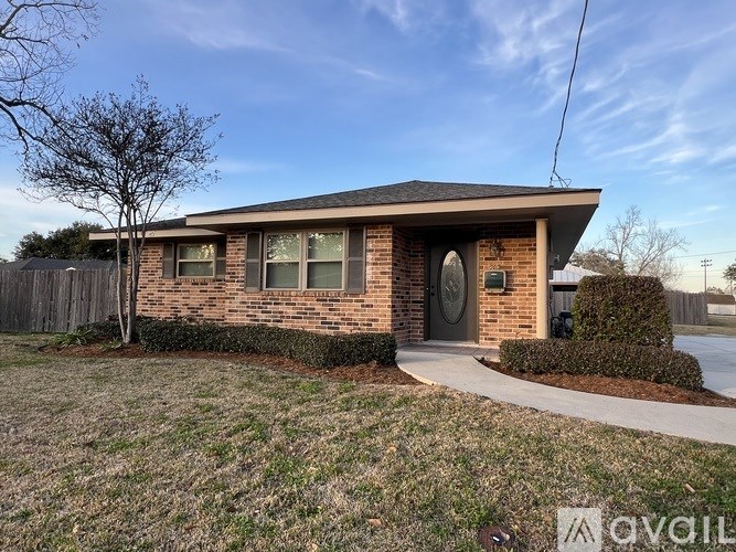 A brick house with a grey roof and a grey door.