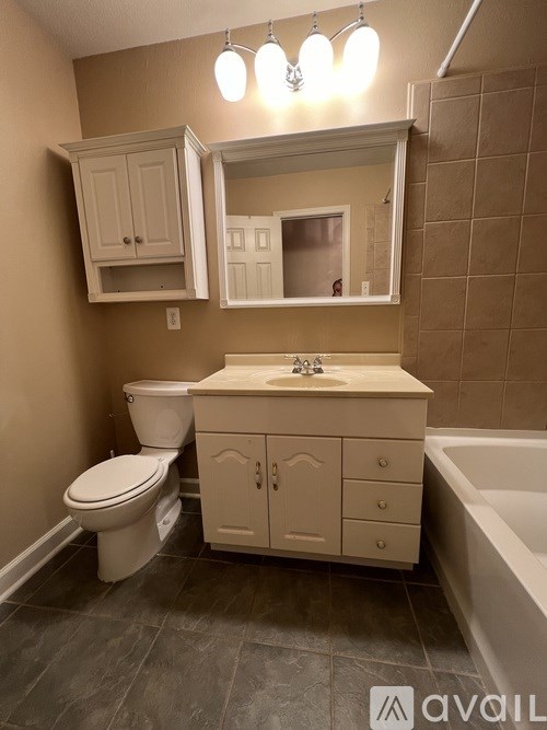 A bathroom with a toilet, sink, and bathtub.