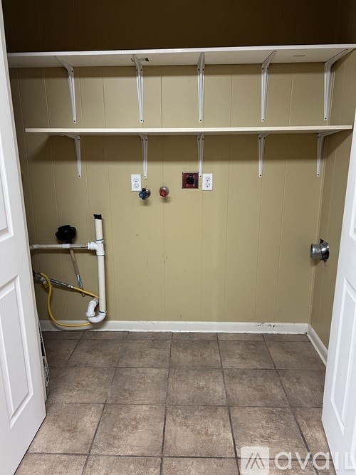 A bathroom with a white door and a white pipe running along the wall.
