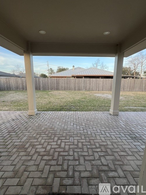 A patio with a brick pattern floor and a white ceiling.