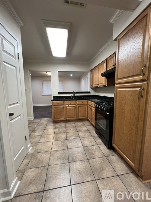 A kitchen with wooden cabinets and a black stove top oven.