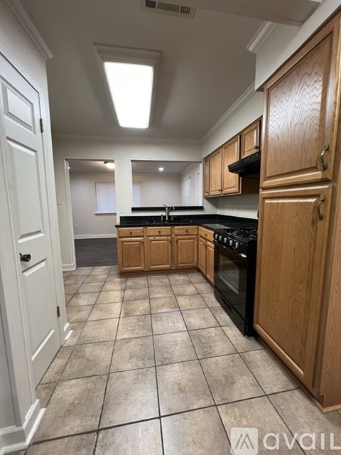 A kitchen with wooden cabinets and a black stove top oven.