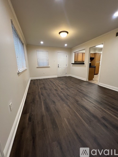 A room with wooden flooring and white walls.