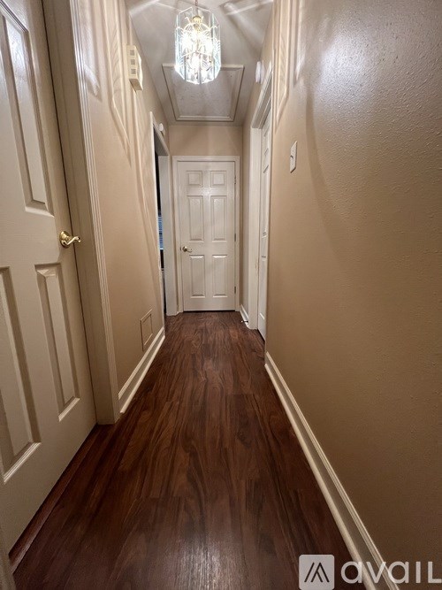 A hallway with wood floors and white doors.