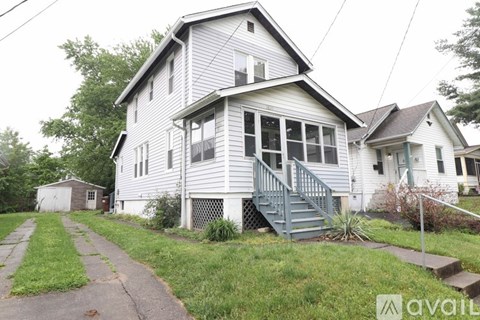 A two-story house with a grey exterior and a small front porch.