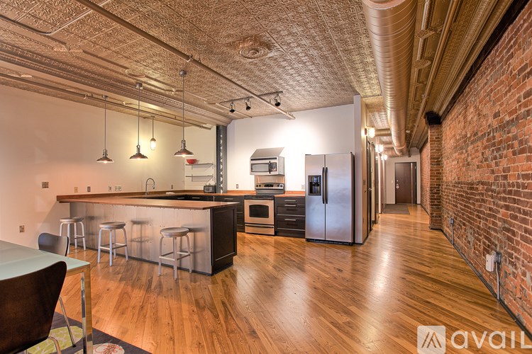 A kitchen with a bar area and a refrigerator.
