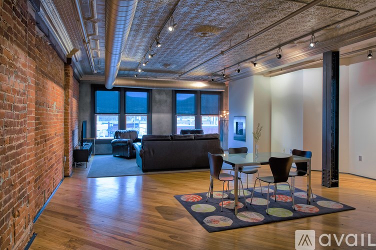 A room with a brick wall and a table with chairs.