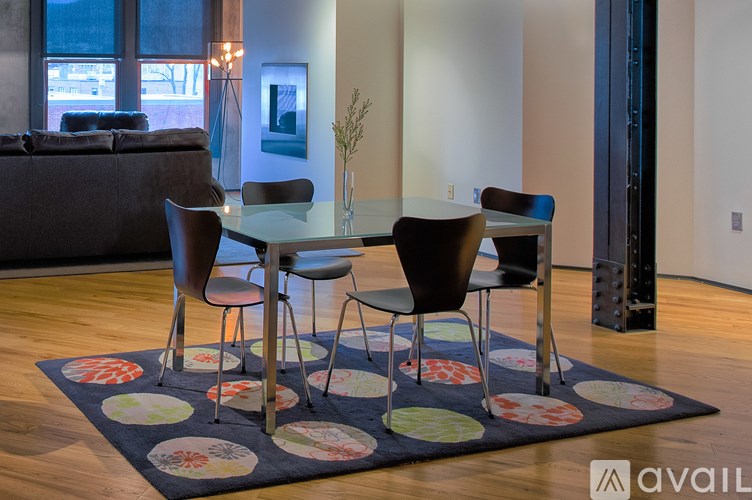 A modern dining room with a glass table and chairs.