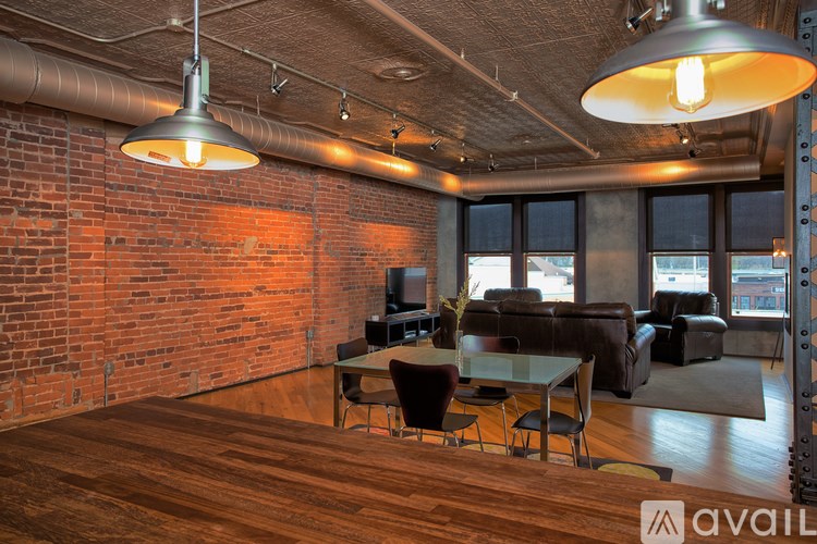 A room with a wooden floor and a brick wall.