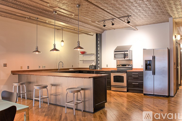 A kitchen with a bar area and a refrigerator.