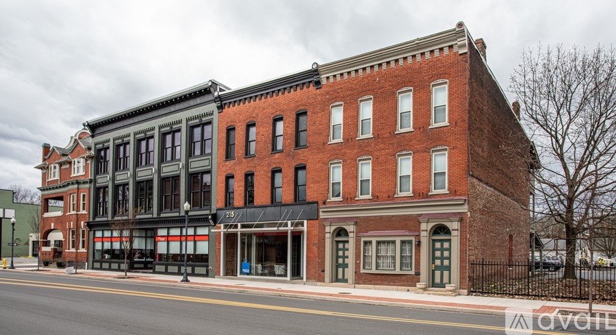 A red brick building with a black awning sits on a street corner.