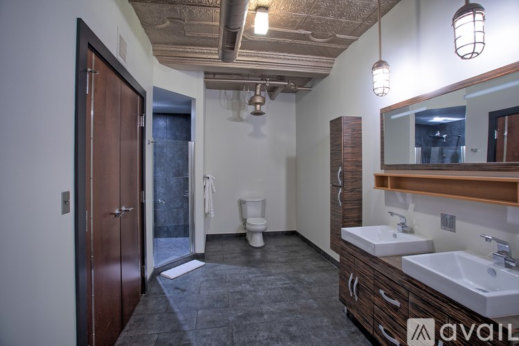 A bathroom with a toilet, sink, and mirror.