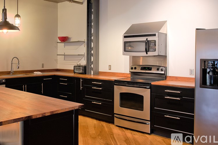 A kitchen with a wooden counter top and stainless steel appliances.