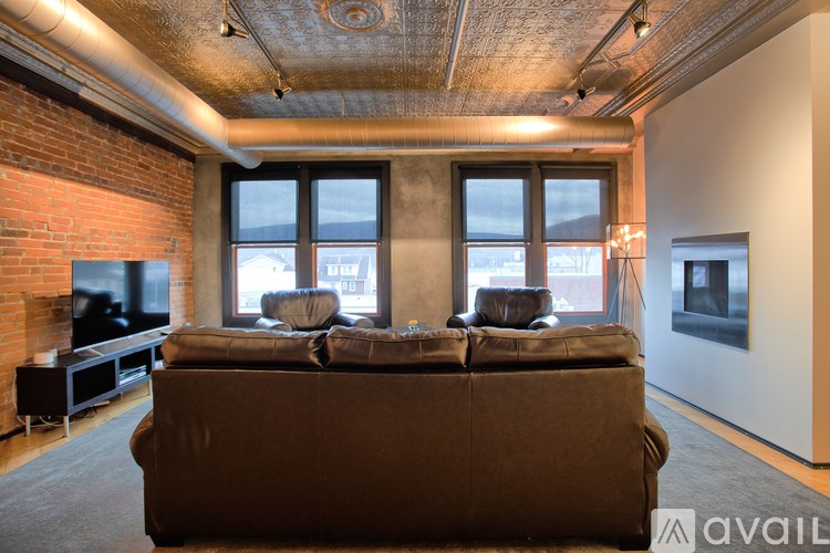 A living room with a brown couch and a fireplace.