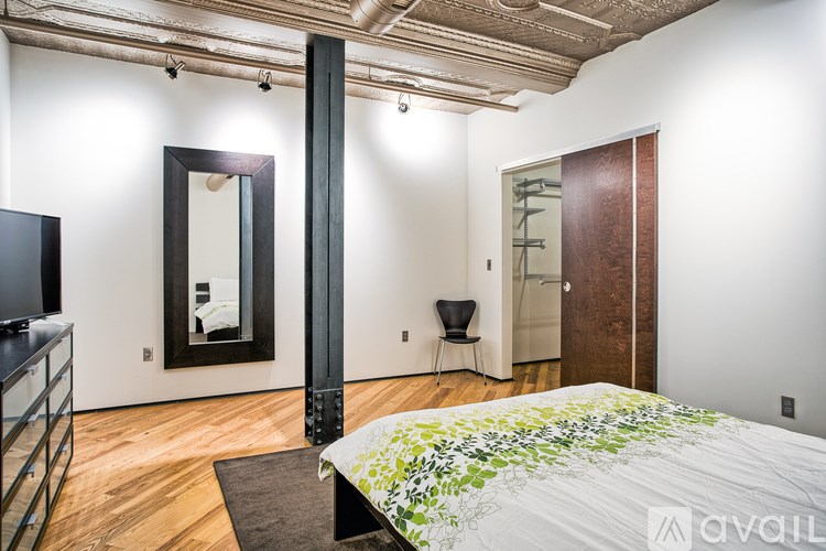 A bedroom with a large bed and a mirror on the wall.