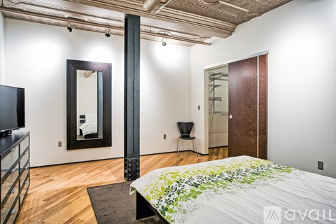 A bedroom with a large bed and a mirror on the wall.