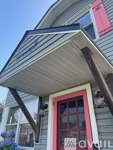 A house with a red door and a sign that says "Sunset Harbour".