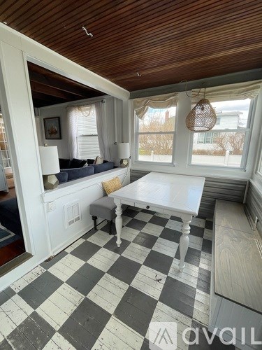 A room with a checkered floor and a table with a white tablecloth on it.
