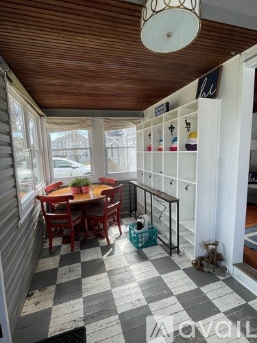 A dining room with a checkered floor and a wooden ceiling.