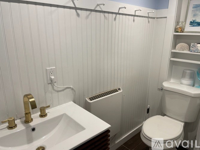 A white bathroom with a toilet, sink, and towel rack.
