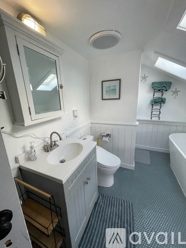 A bathroom with a white sink and toilet.