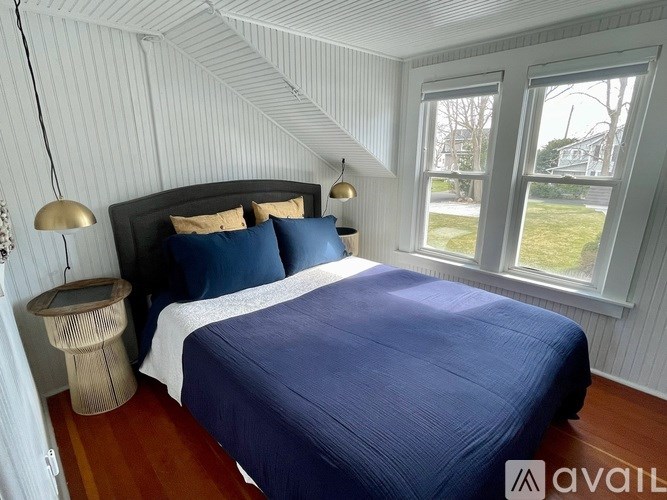 A bedroom with a bed, nightstand, and two lamps.