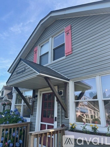 A house with a red door and a sign that says "avail" in front of it.