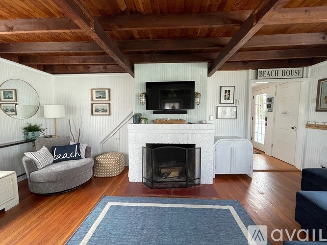 A living room with a fireplace and a sign that says "Beach House".