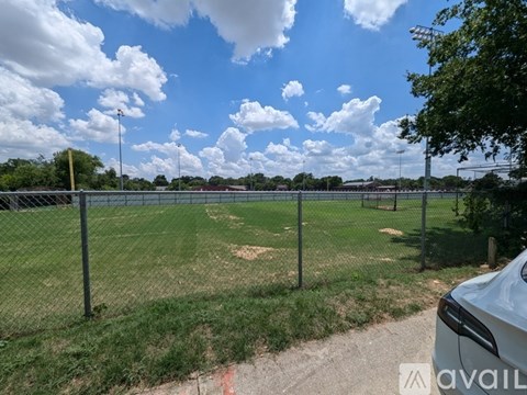 A fenced field with a cloudy sky above.
