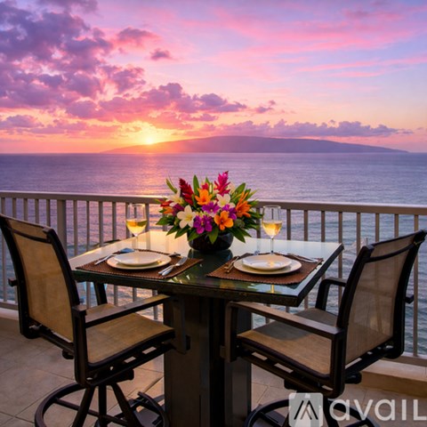 A living room with a bar area and a view of the ocean.