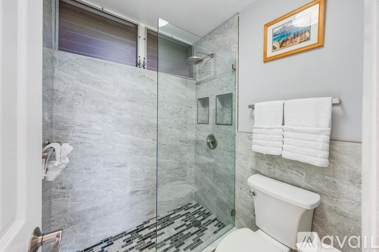 A balcony with a table set for two overlooks a beautiful ocean view.