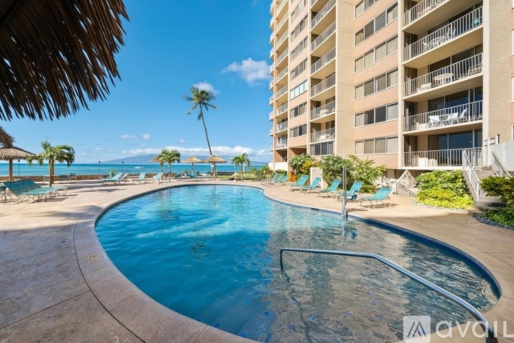 A swimming pool with a view of the ocean and palm trees.