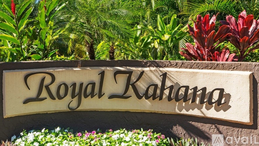 A sign that says "Royal Kahana" is in front of some flowers.