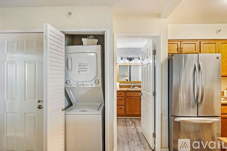 A kitchen with a refrigerator and a stove top oven.