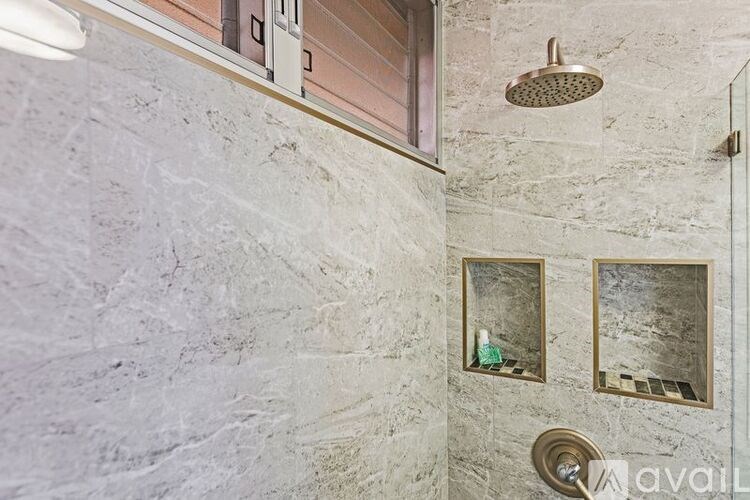 A bathroom with a shower head and two mirrors.