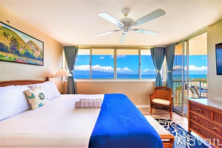 A bedroom with a large bed and a view of the ocean.