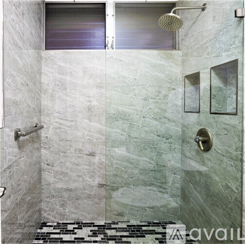 A bathroom with a walk in shower and a glass door.