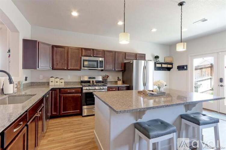 A kitchen with brown cabinets and a granite countertop.