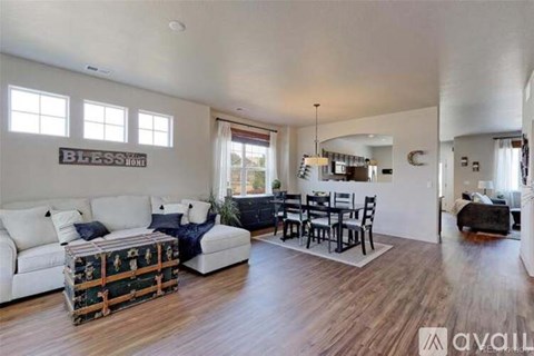 A living room with a white couch and a wooden floor.