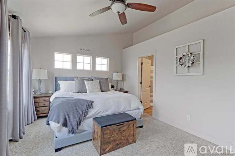 A bedroom with a large bed and a ceiling fan.
