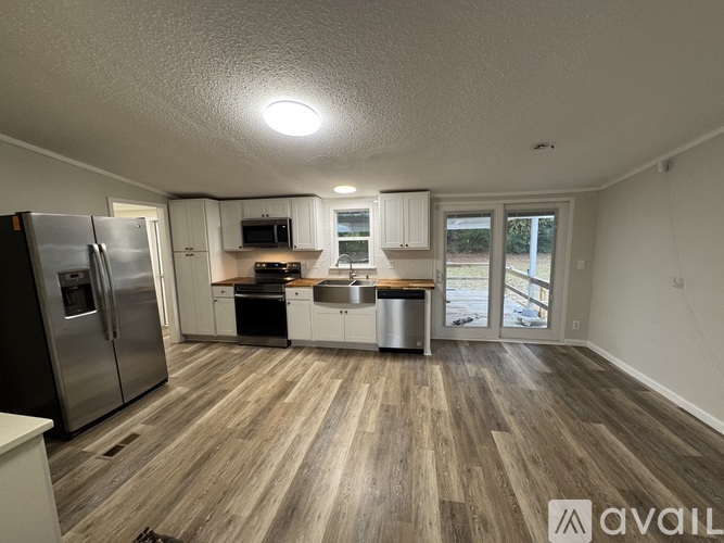 A kitchen with a refrigerator, microwave, oven, and sink is available for rent.